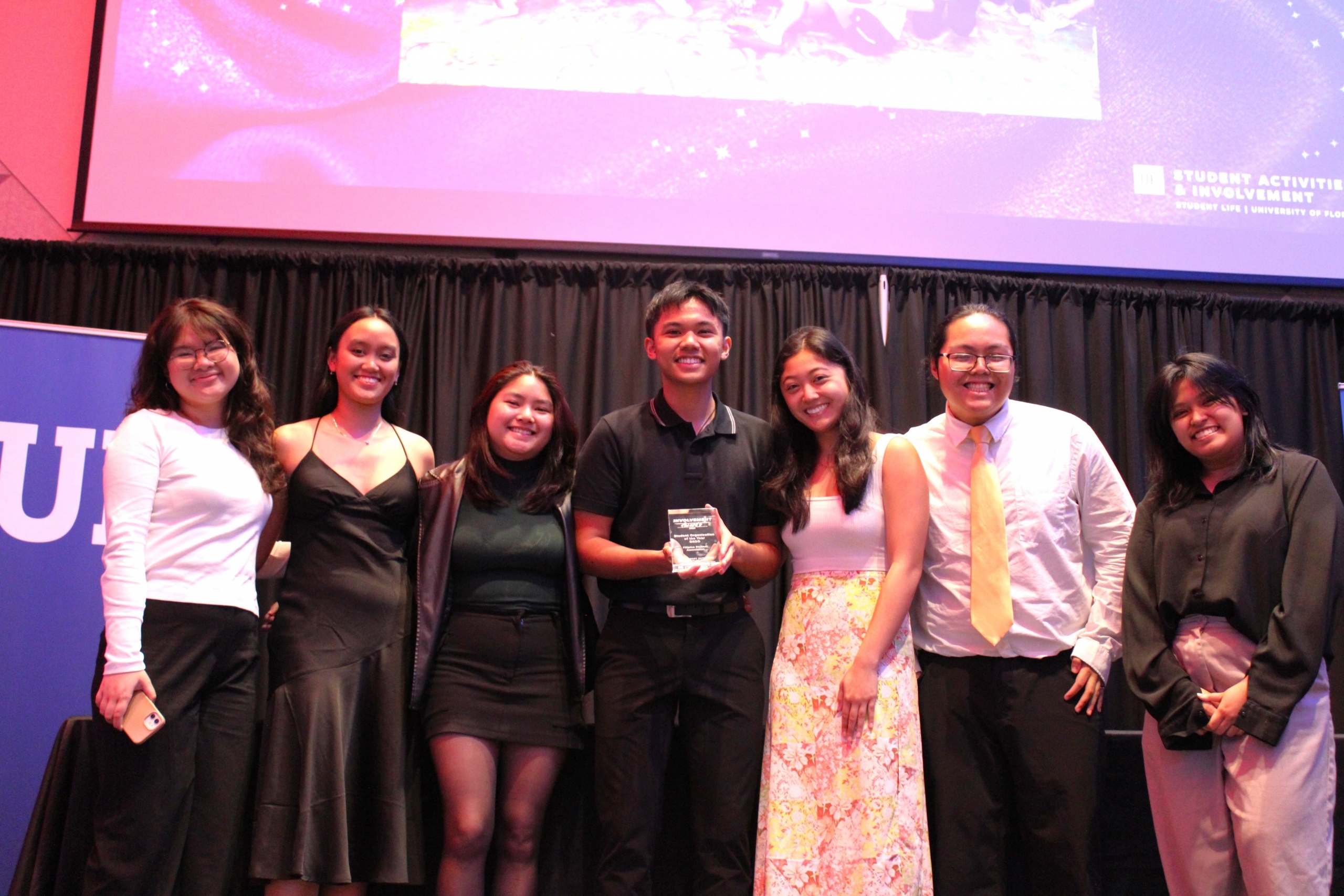 group of students receiving an award and smiling at camera