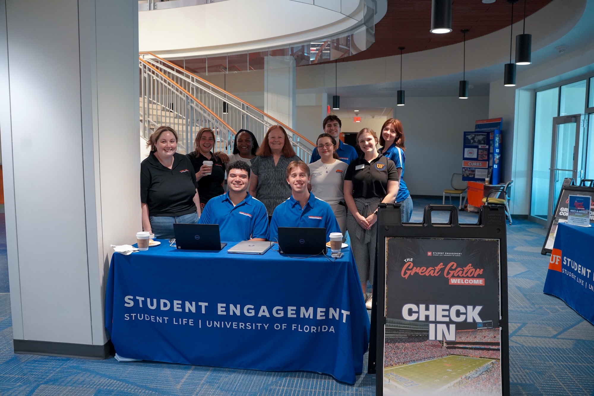 Student Engagement and Campus Partner staff smiling around a table at a Great Gator Welcome Event from the Fall.