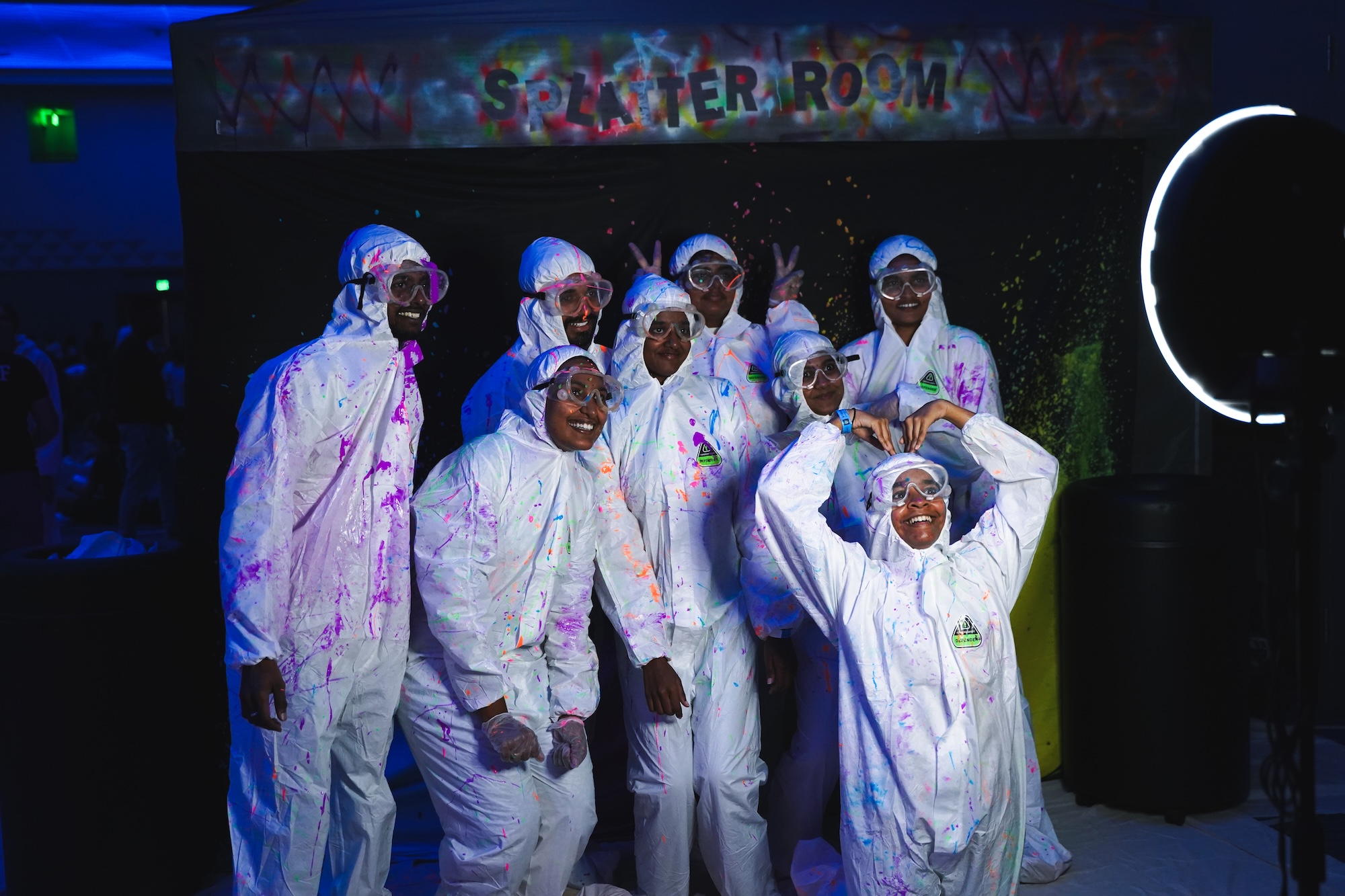 Students dressed in white posing for a photo at GatorNights after throwing paint at one another.