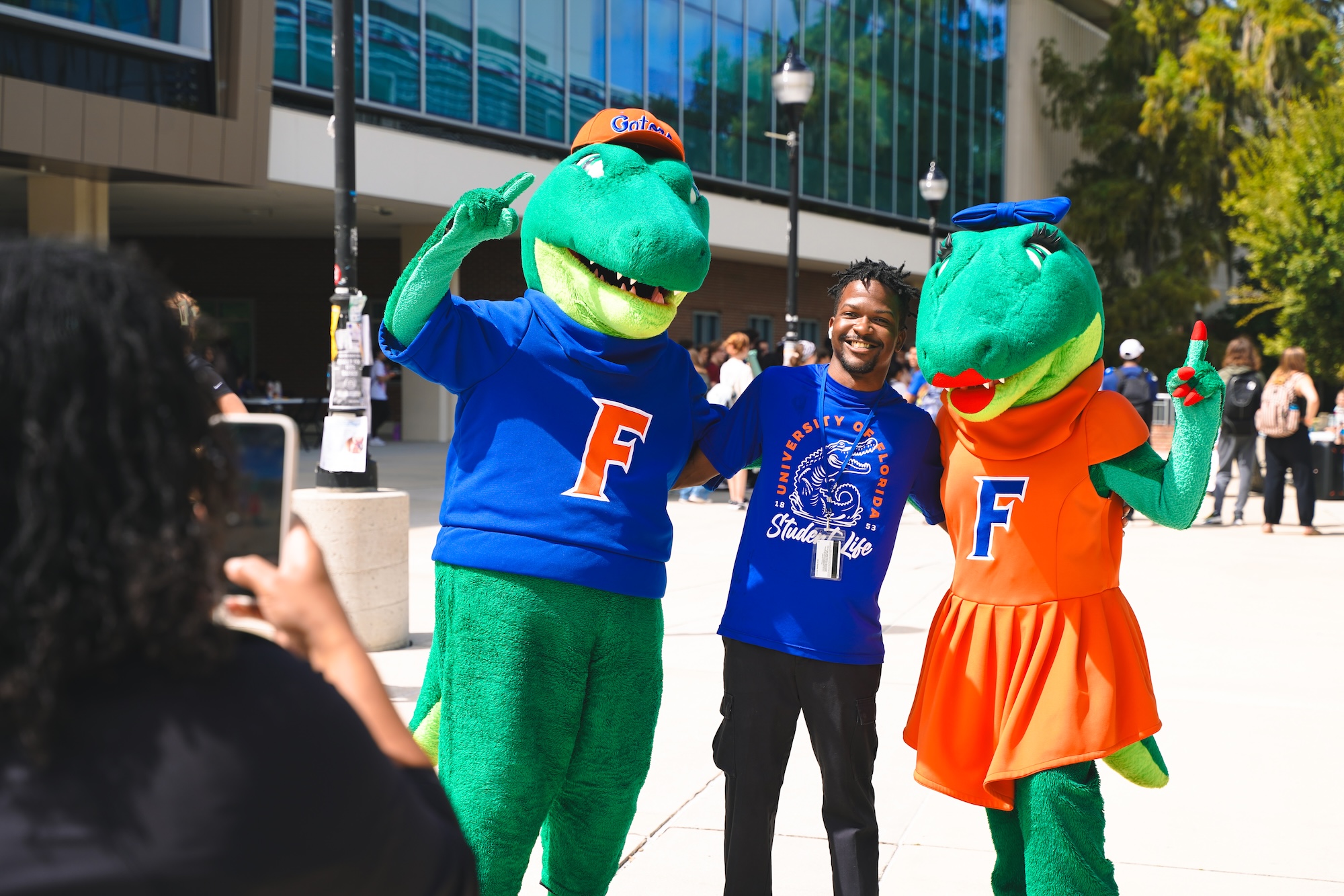 Albert and Alberta posing with someone and smiling at a camera