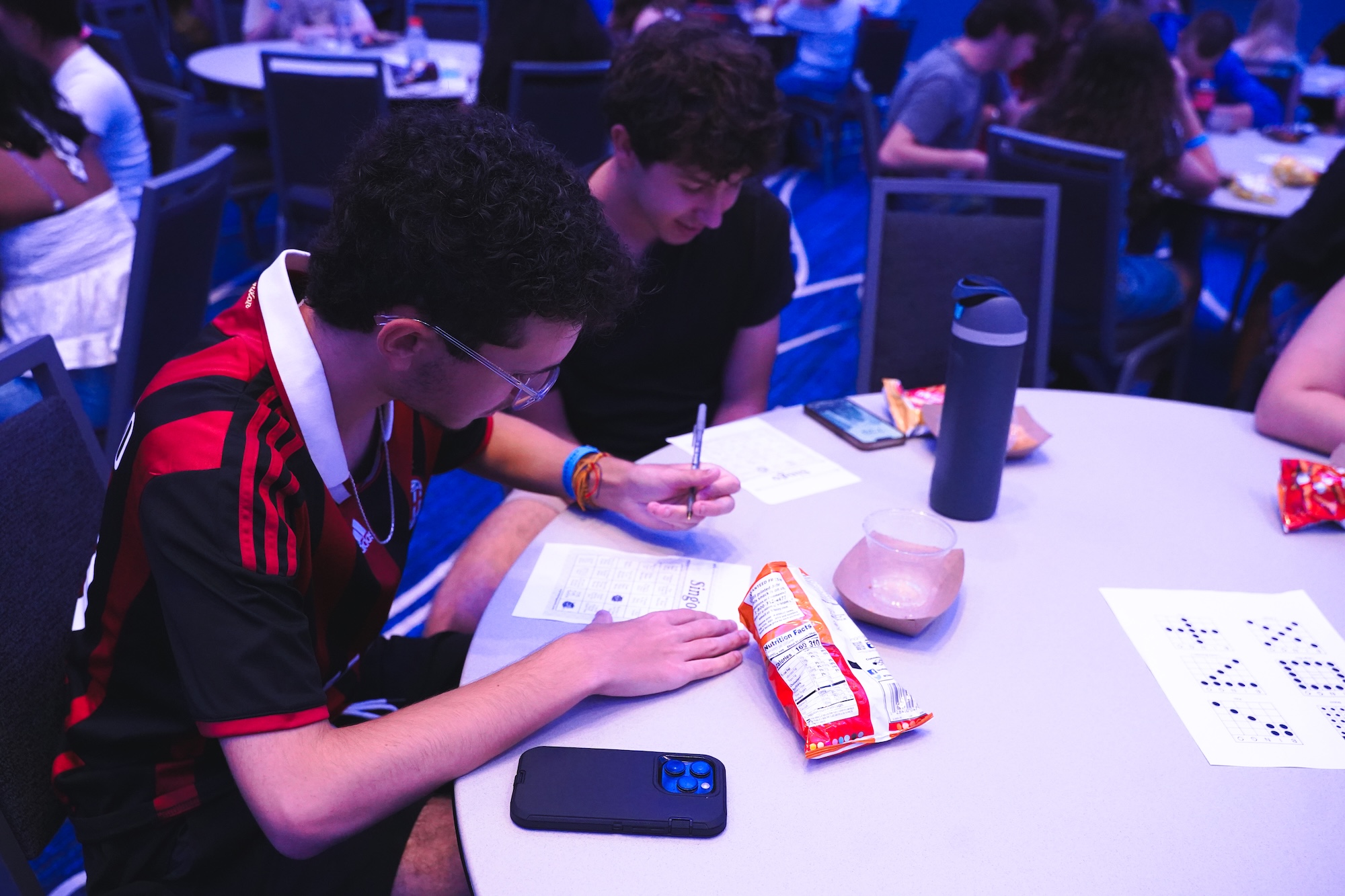 Two students looking at their singo card to see if they can check off another box.