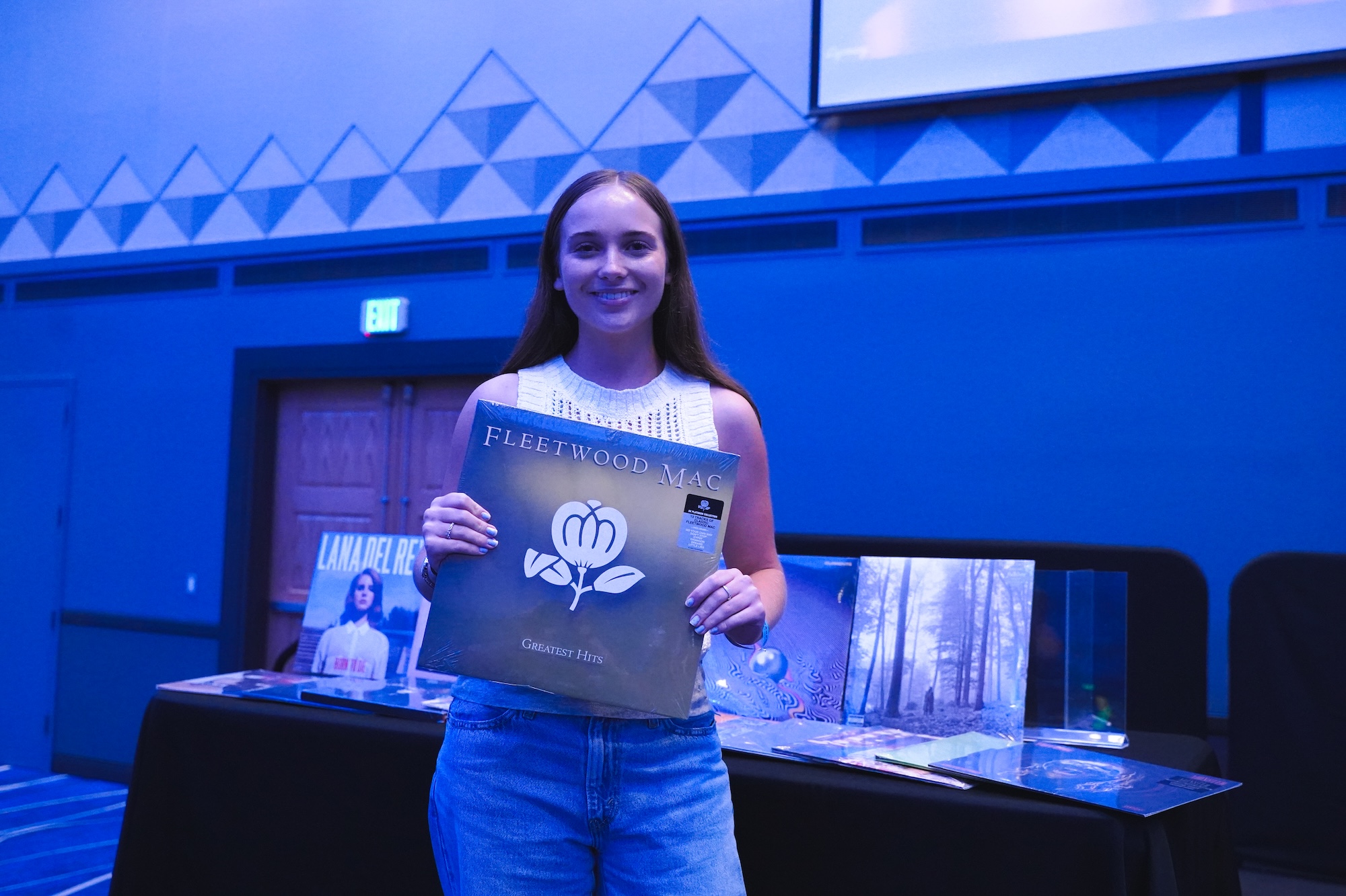 Female student holding up the album she chose after winning a round of Singo.